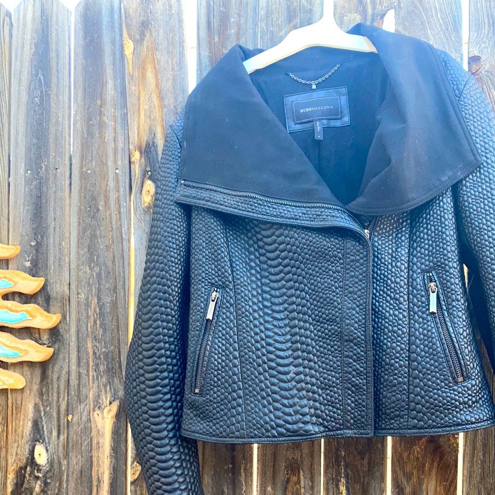 black textured leather look with black cotton material inserts on sleeves.